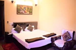 a bedroom with a bed and two chairs at DS Residency-Near Ghats N Temples-Parking-Free Wi-Fi in Varanasi