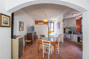 una cucina e una sala da pranzo con tavolo e sedie di Casa Max - Venturina Terme a Campiglia Marittima