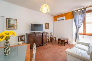 a living room with a couch and a tv at Casa Max - Venturina Terme in Campiglia Marittima