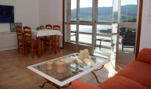 a living room with a table and a dining room with a view at Campelo playa in Poio