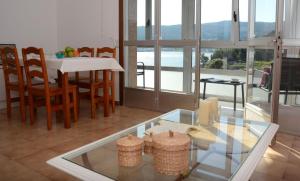 a living room with a table and chairs and a glass table at Desconectaenlasriasbaixas Campelo playa in Poio