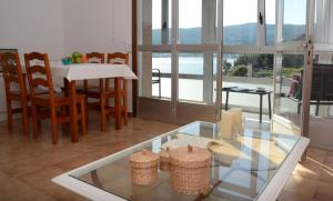 a living room with a table and chairs and a glass table at Campelo playa in Poio