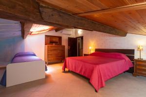 a bedroom with a red bed and a wooden ceiling at Casa Max - Venturina Terme in Campiglia Marittima