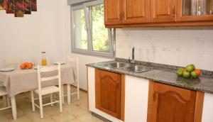 a kitchen with a sink and a table with a dining room at Desconectaenlasriasbaixas Campelo playa in Poio +23 photos