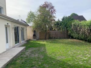 un patio junto a una casa con una valla en Villa Tenjin chambre 7, en Bondy
