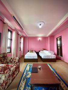 salon z 2 łóżkami i kanapą w obiekcie The Nest Guest House w mieście Changunarayan