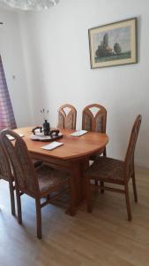 uma mesa de madeira com quatro cadeiras à volta em Apartma Caprivi Zavod za razvoj turizma Kočevski rog em Kocevje