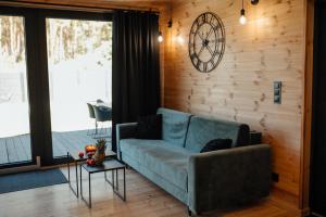 a living room with a couch and a clock on the wall at REST Rusinowo in Rusinowo