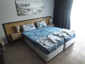 a bedroom with a bed with blue sheets and pillows at Park and pool Studio Apostolovi in Nesebar