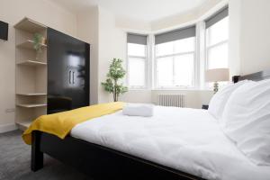 a bedroom with a large bed with a yellow blanket on it at ALTIDO Haymarket in Edinburgh