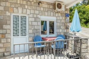 a patio with chairs and a table and a blue umbrella at Apartments Bonaca in Igalo