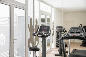 a gym with two treadmills and two ellipticals at Aparthotel Marina Drach in Porto Cristo