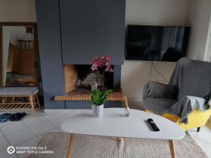 a living room with a white coffee table and a fireplace at Little Summer Chalet in Saronida