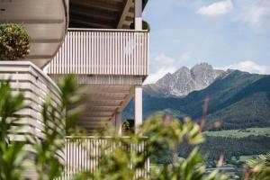 a house with a balcony with mountains in the background at Appartementhaus Residence Hirzer in Tirolo