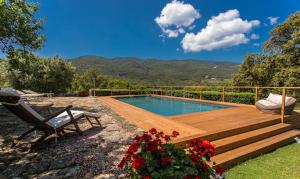 a swimming pool with a wooden deck and a chair at Country Relais La Mortella in Porto Ercole