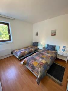 a bedroom with two beds and a window at Apartments Kosljun 123 in Košljun