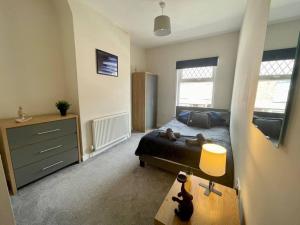 a bedroom with a bed and a table in it at Western House - By Sigma Stays in Crewe