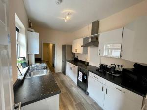 a kitchen with a sink and a counter top at Western House - By Sigma Stays in Crewe