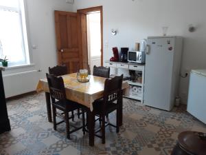 uma cozinha com uma mesa e cadeiras e um frigorífico em AU COEUR DE L'ENCLAVE em Moeuvres