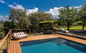 a swimming pool with a wooden deck next to at Country Relais La Mortella in Porto Ercole