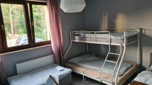 Pokój z łóżkiem piętrowym z 2 łóżkami piętrowymi i oknem w obiekcie Urocze Apartamenty na Wsi w mieście Golędzinów