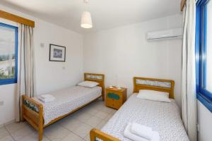 2 camas en una habitación con ventana en Villa Alexelio by Villa Plus, en Argaka