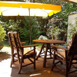 una mesa de picnic y sillas bajo una sombrilla en kunst-at-home en Bad Zwischenahn