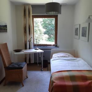 1 dormitorio con cama, escritorio y ventana en kunst-at-home en Bad Zwischenahn