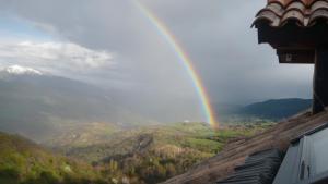 un arco iris sobre un valle con una montaña en Apartamento Neril en Laspaúles