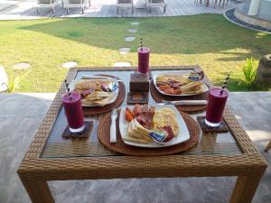 una mesa de picnic con dos platos de comida y bebida en Ceningan Beachside Villas en Lembongan