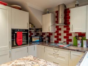 a kitchen with white cabinets and red and white tiles at Pass the Keys Private 2 Bedroom Gem with parking in Christchurch