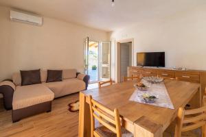 a living room with a table and a couch at Casa vacanza Il Melograno in Santa Maria Del Focallo