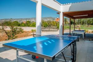 a ping pong table on the patio of a house at Villa Cypria Maria by Villa Plus in Peyia
