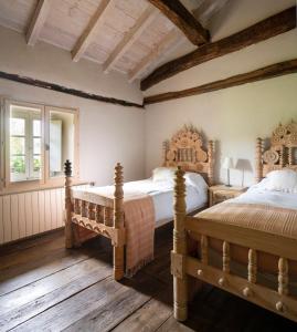 2 camas num quarto com pisos em madeira em Ulle Gorri Rural House - Casa Rural em Unzá
