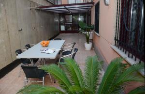 Raxó con piscina en la urbanización في راكسو: طاولة بيضاء وكراسي على شرفة بها نباتات