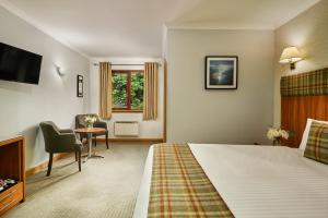a hotel room with a bed and a desk at Clan Macduff Hotel in Fort William