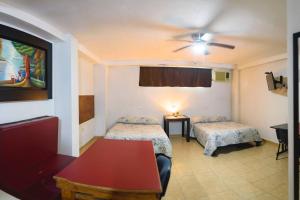 a hotel room with two beds and a table at DepaB privado, centrico,Wifi 80 mb ,aire acondicionado ,cocina, cochera techada, in Ciudad Valles