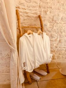 a bunch of white clothes sitting on a wooden chair at EnjoyTrulli - Unesco Site in Alberobello