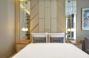 um quarto com uma grande cama branca e 2 almofadas em THE HUBİ HOTEL em Istambul