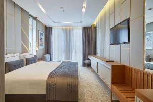 um quarto de hotel com uma cama grande e uma televisão em THE HUBİ HOTEL em Istambul