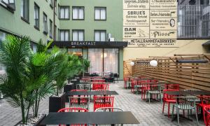 a restaurant with red chairs and tables in front of a building at Thon Hotel Astoria in Oslo