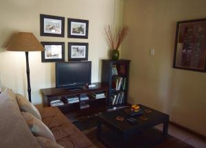 A television and/or entertainment centre at Kruger River Holiday Home