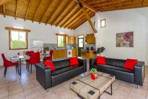una sala de estar con muebles de cuero negro y almohadas rojas en Villa Poppy by Villa Plus, en Polis Chrysochous