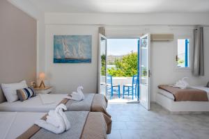 ein Hotelzimmer mit zwei Betten und Balkon in der Unterkunft Ayeri Hotel in Parikia
