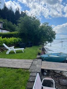 a yard with a tub and a bench next to the water at Haus am See in Henndorf am Wallersee