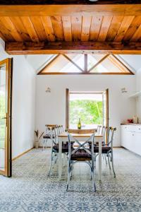 comedor con mesa, sillas y ventana en Balatoncsicsói Borhaz, en Balatoncsicsó