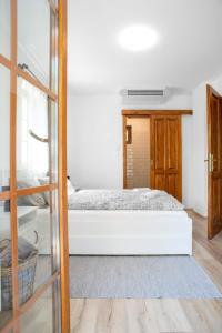 Un dormitorio con una cama blanca y una escalera en Balatoncsicsói Borhaz, en Balatoncsicsó