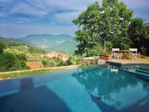einen Pool mit einem Tisch und Stühlen neben einem Berg in der Unterkunft Villa Barca - Luxury Vacation Rentals - Wellness & Pool in Casanova Lerrore