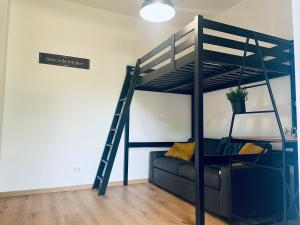 a bunk bed with a couch and a ladder at Trevi industrial room C in Milan