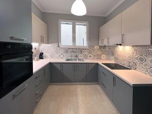 uma cozinha com armários brancos e um aparelho preto em Panoramic Apartment em Quios